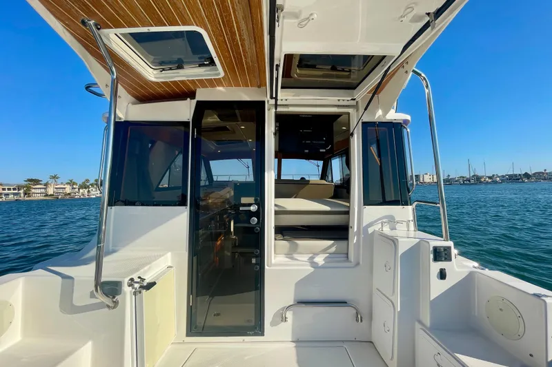 Slide: The Image of 2019 Cutwater C-302 Coupe boat interior with open cabin door, docked on calm water. - 14