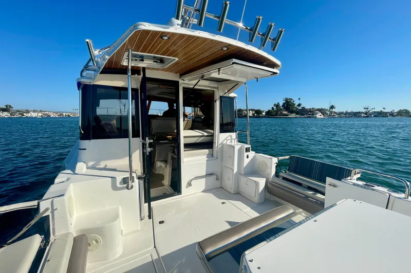 Slide: The Image of 2019 Cutwater C-302 Coupe boat with open deck, docked on calm waters. - 15