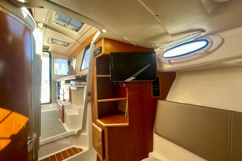 Slide: The Image of Interior of 2019 Cutwater C-302 Coupe boat with wood accents and a mounted TV. - 17