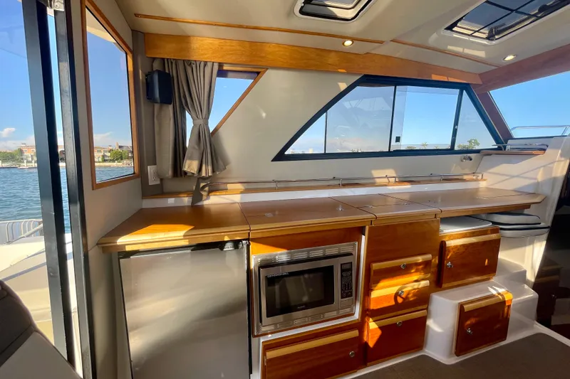 Slide: The Image of Interior of 2019 Cutwater C-302 Coupe with wooden cabinetry and modern appliances. - 19