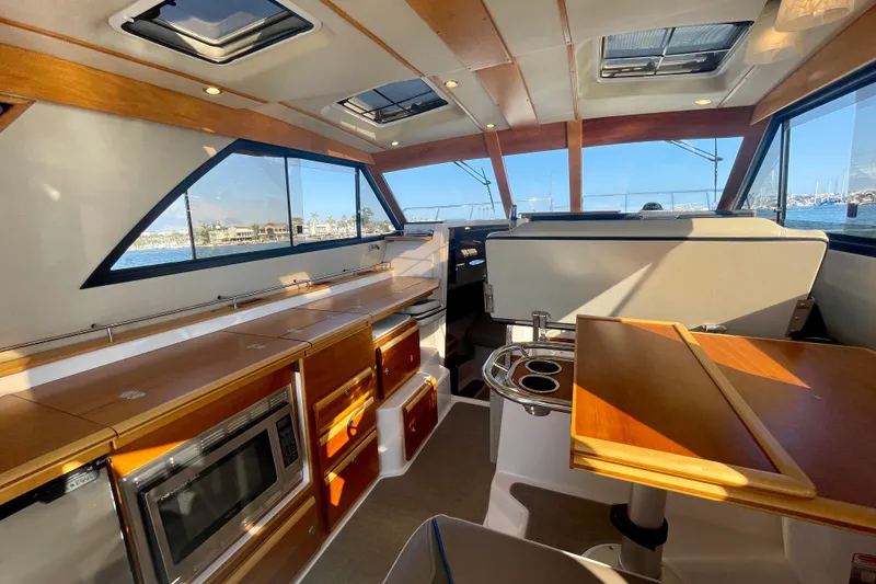 Slide: The Image of Interior of 2019 Cutwater C-302 Coupe boat with modern kitchen and seating area. - 20