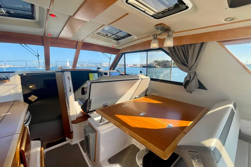 Slide: The Image of Interior of 2019 Cutwater C-302 Coupe boat with dining area and scenic window view. - 22