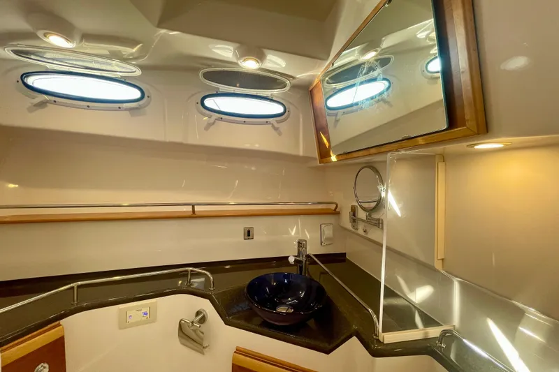 Slide: The Image of Luxurious bathroom interior of 2019 Cutwater C-302 Coupe with modern fixtures and porthole windows. - 28
