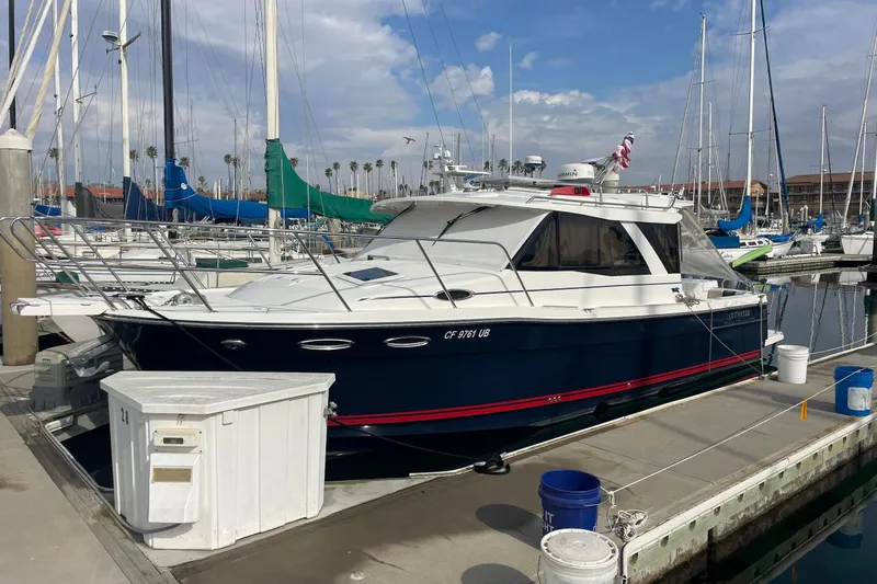 Slide: The Image of 2019 Cutwater C-302 Coupe boat docked at marina under clear blue sky. - 4