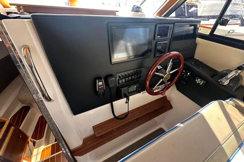 Slide: The Image of 2019 Cutwater C-302 Coupe helm with steering wheel, navigation screens, and control panel. - 8