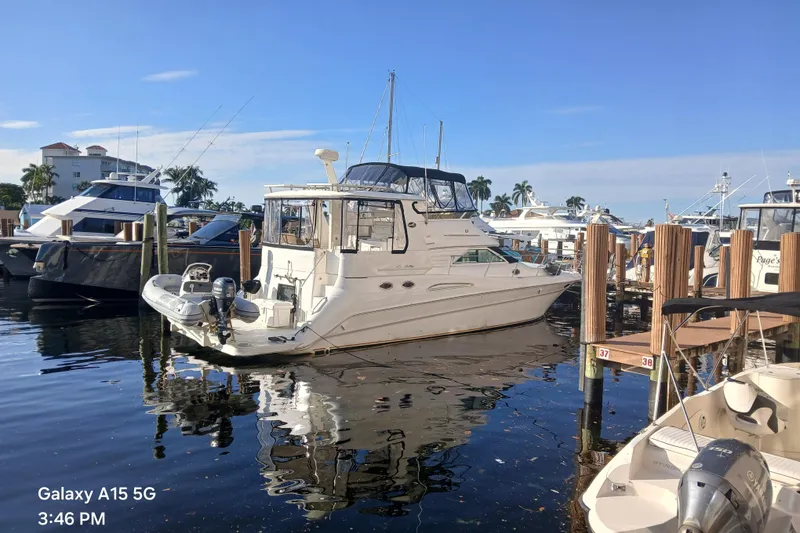 The Image of 2000 Sea Ray 420 Aft Cabin yacht docked at marina under clear blue sky. - 0