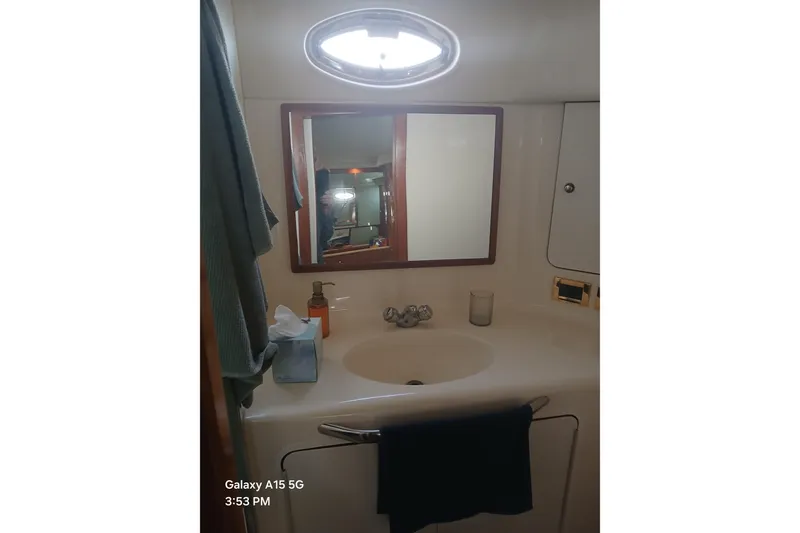 Slide: The Image of Bathroom vanity in 2000 Sea Ray 420 Aft Cabin yacht, featuring sink and mirror. - 12