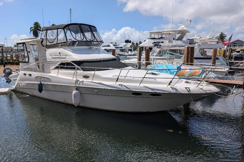 Slide: The Image of 2000 Sea Ray 420 Aft Cabin yacht docked at marina under clear sky. - 2