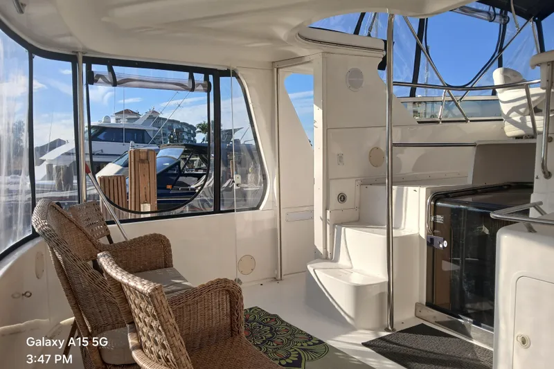 Slide: The Image of Interior of 2000 Sea Ray 420 Aft Cabin yacht with wicker chairs and marina view. - 7