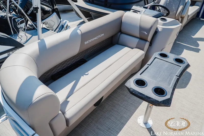 Slide: The Image of 2024 Bennington 22SSR-SPS pontoon boat interior with plush seating and cupholder table. - 15
