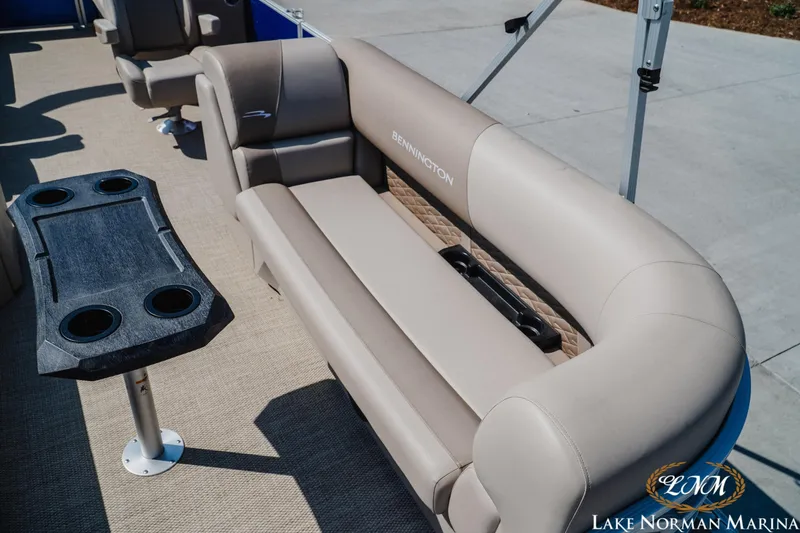 Slide: The Image of 2024 Bennington 22SSR-SPS pontoon boat with beige seating and cupholder table at Lake Norman Marina. - 16
