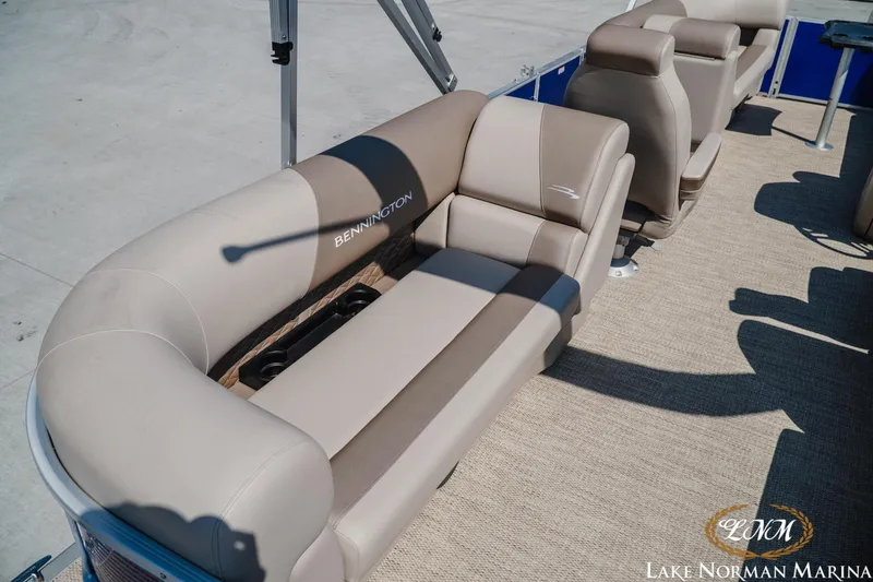 Slide: The Image of 2024 Bennington 22SSR-SPS pontoon boat interior with beige seating and cup holders. - 7