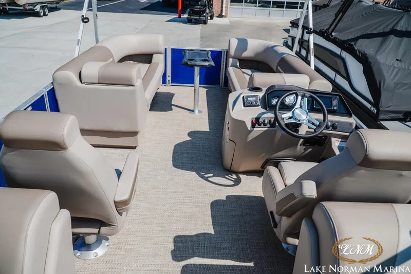 Slide: The Image of 2024 Bennington 22SSR-SPS pontoon boat interior with beige seating and steering console. - 9