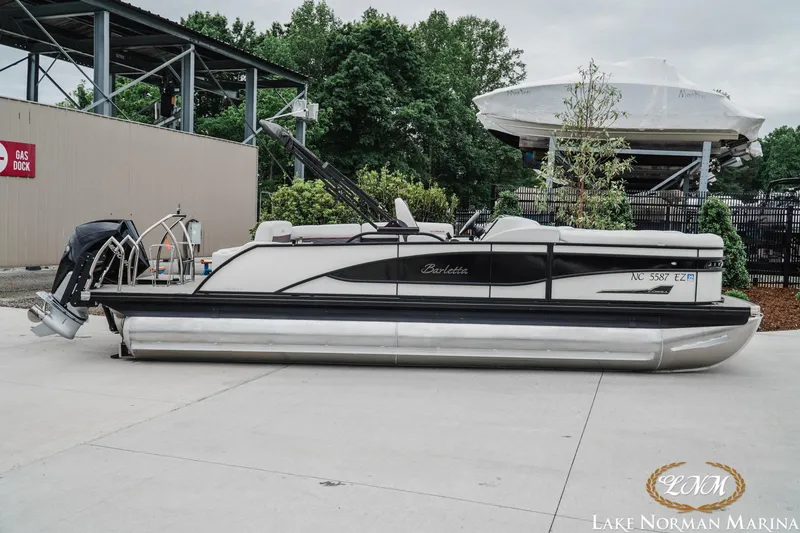 The Image of 2023 Barletta X23U pontoon boat at Lake Norman Marina, parked near gas dock. - 1