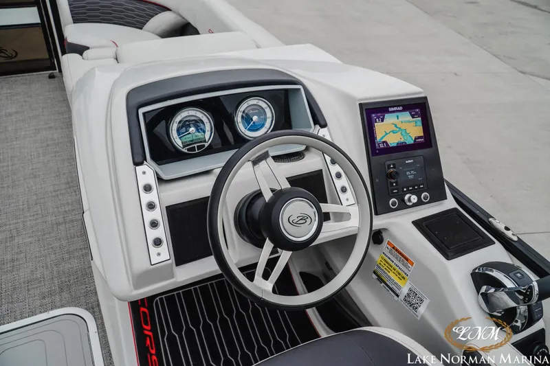 Slide: The Image of 2023 Barletta X23U boat dashboard with steering wheel and navigation display. - 12