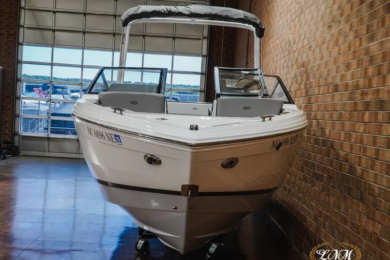 Slide: The Image of 2025 Cobalt R4 boat in showroom, sleek design, white exterior, brick wall background. - 4
