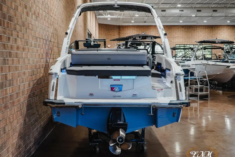 Slide: The Image of 2025 Cobalt R4 boat displayed in a showroom, rear view with propeller visible. - 7