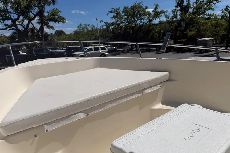 Slide: The Image of 2004 Key West 186 Sportsman boat interior with seating and cooler, parked outdoors. - 12