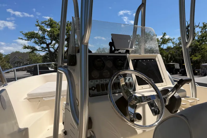 Slide: The Image of 2004 Key West 186 Sportsman boat dashboard with steering wheel and controls under clear blue sky. - 14