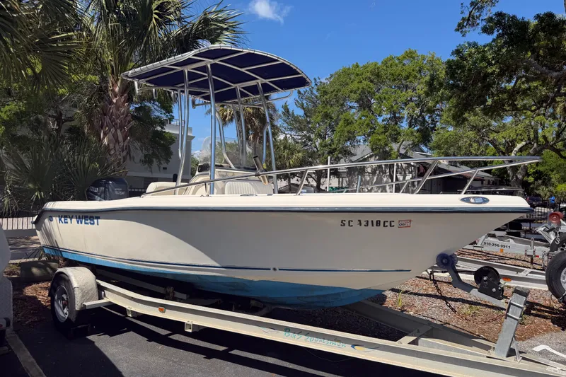 Slide: The Image of 2004 Key West 186 Sportsman boat on trailer, parked under palm trees. - 3