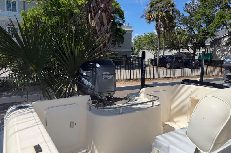 Slide: The Image of 2004 Key West 186 Sportsman boat with Yamaha 150 engine, parked near palm trees. - 8