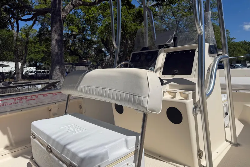 Slide: The Image of 2004 Key West 186 Sportsman boat interior with seating and console, surrounded by trees. - 9