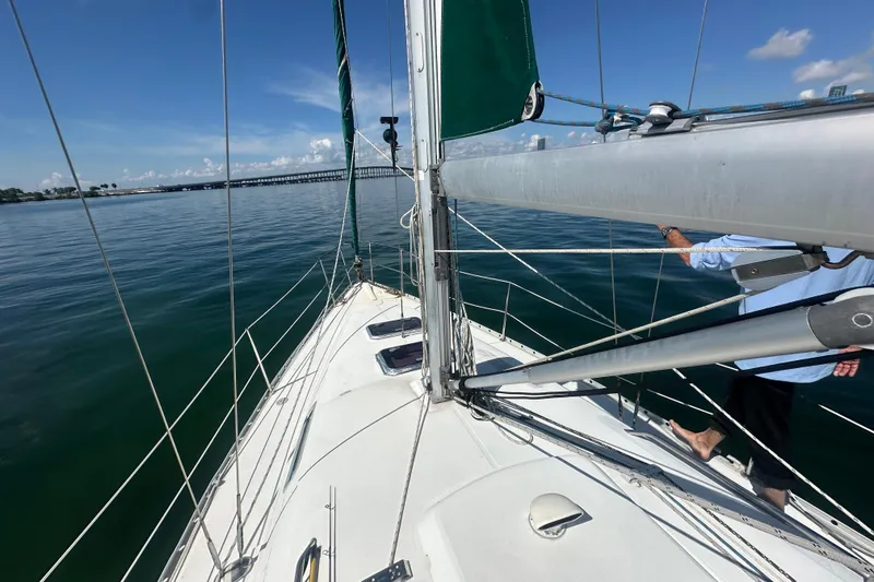 Slide: The Image of 2003 Beneteau Oceanis Clipper 331 sailboat on calm waters under clear blue sky. - 16
