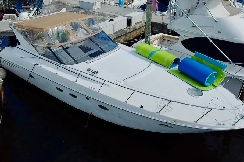 The Image of 2000 Trojan 440 Express yacht docked with colorful mats on deck. - 0