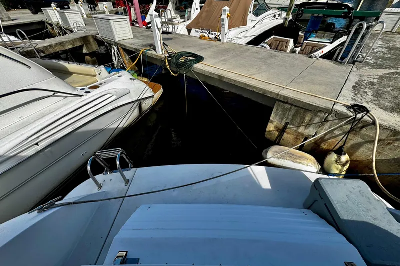 Slide: The Image of Docked boats at marina, featuring a 2000 Trojan 440 Express yacht. - 16
