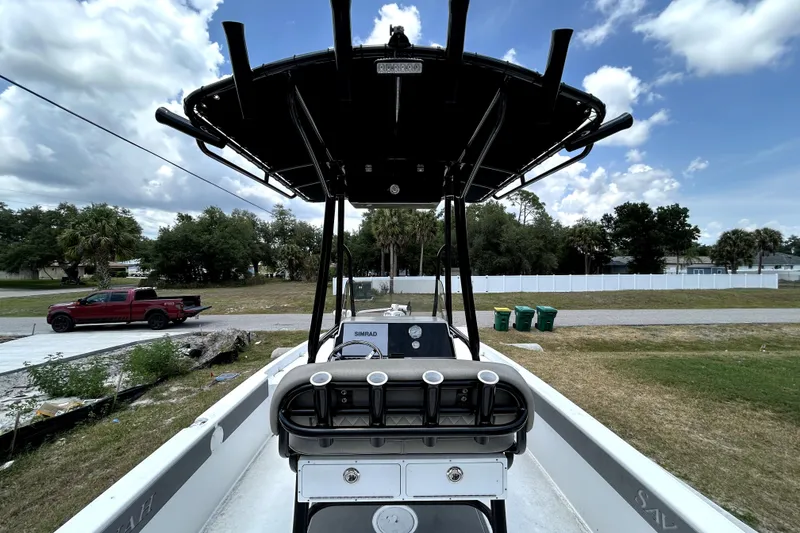 Slide: The Image of 2025 Savannah 210X boat with T-top, parked outdoors under a cloudy sky. - 14