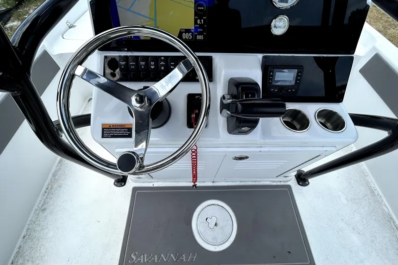 Slide: The Image of 2025 Savannah 210X boat dashboard with steering wheel and navigation controls. - 19