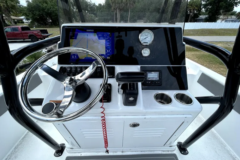 Slide: The Image of 2025 Savannah 210X boat dashboard with steering wheel, navigation display, and control panel. - 20
