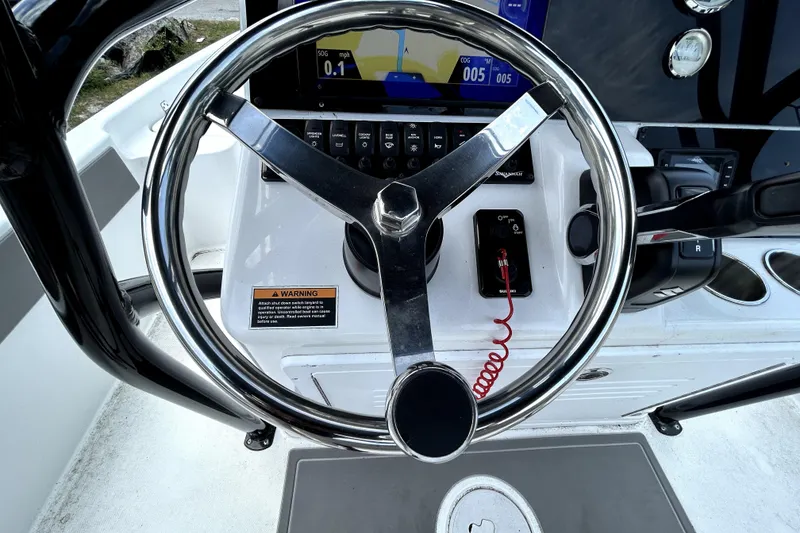 Slide: The Image of Steering wheel and dashboard of 2025 Savannah 210X boat, featuring modern controls and display. - 21