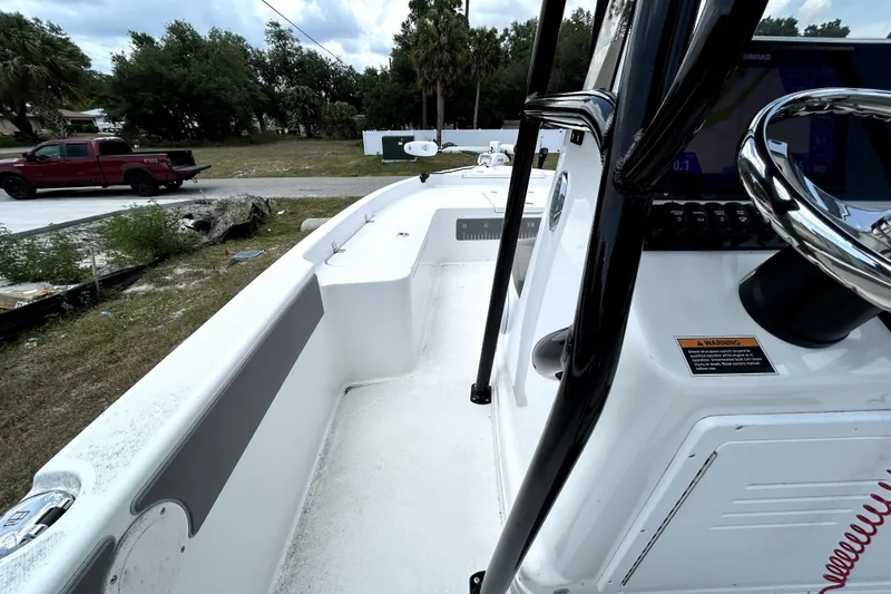 Slide: The Image of 2025 Savannah 210X boat interior with steering wheel and console, parked outdoors. - 28