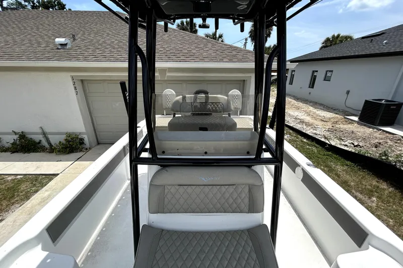 Slide: The Image of 2025 Savannah 210X boat interior with quilted seats, parked near residential garage. - 44