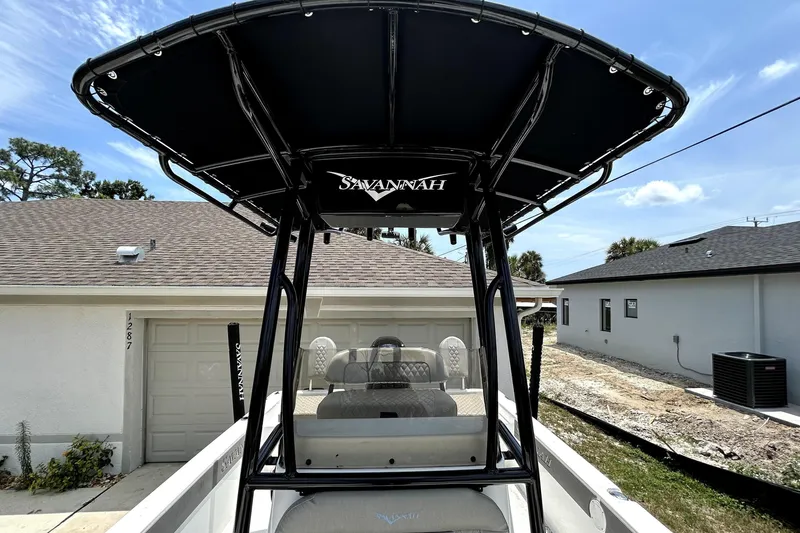 Slide: The Image of 2025 Savannah 210X boat with T-top canopy, parked in residential driveway. - 45
