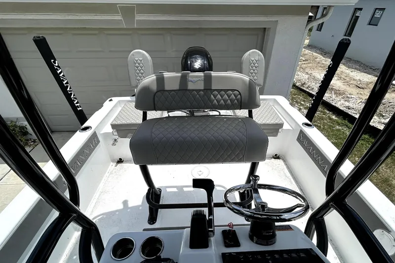 Slide: The Image of 2025 Savannah 210X boat interior with steering wheel, controls, and cushioned seating. - 48