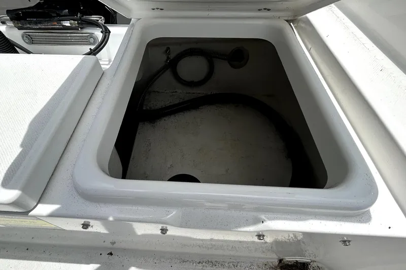Slide: The Image of Open storage compartment in 2025 Savannah 210X boat, showing interior details and wiring. - 54