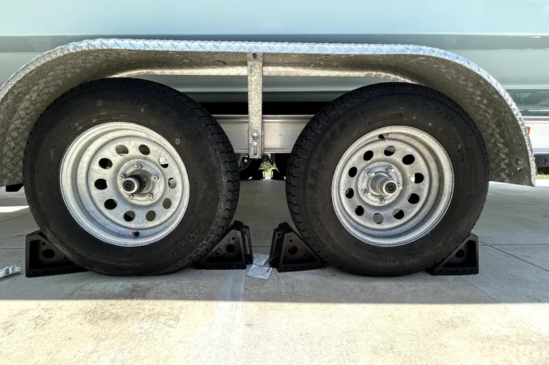 Slide: The Image of Trailer wheels of a 2025 Savannah 210X, secured with wheel chocks on concrete. - 62
