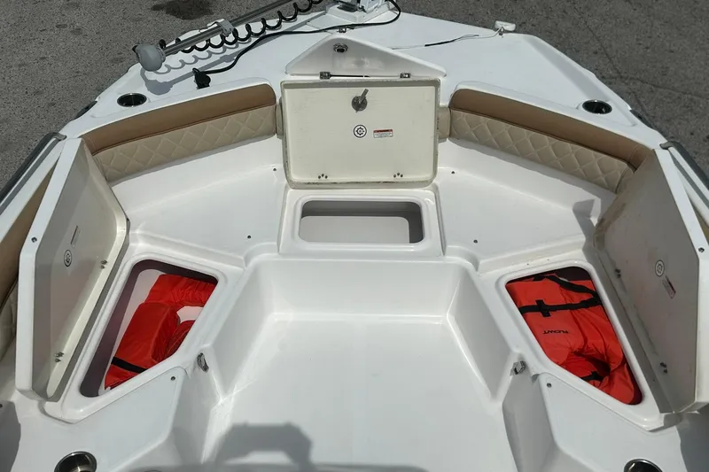 Slide: The Image of 2024 NauticStar 211 Hybrid boat interior with storage compartments and life jackets. - 11