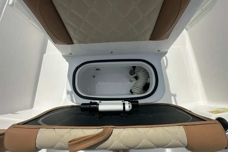 Slide: The Image of 2024 NauticStar 211 Hybrid boat seat with storage compartment and hose. - 15