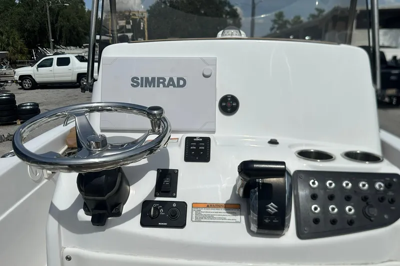 Slide: The Image of 2024 NauticStar 211 Hybrid boat console with Simrad display and steering wheel. - 19