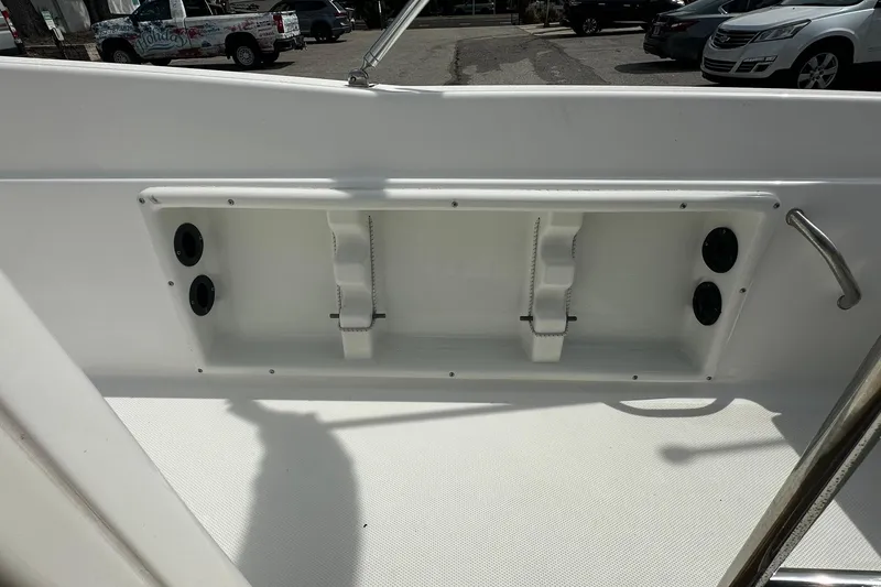 Slide: The Image of 2024 NauticStar 211 Hybrid boat interior detail with storage compartment and cup holders. - 22