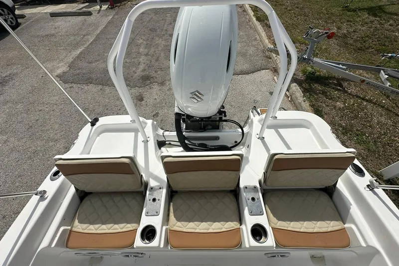 Slide: The Image of 2024 NauticStar 211 Hybrid boat with three cushioned seats and outboard motor. - 26