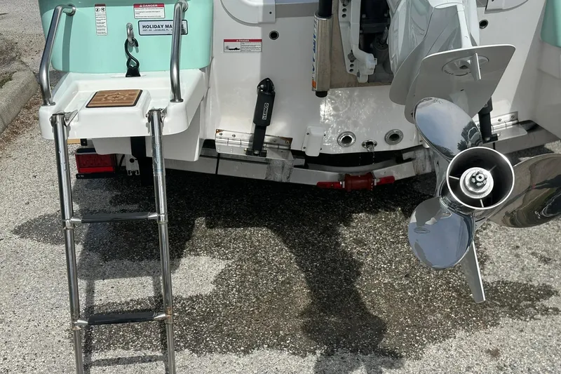 Slide: The Image of 2024 NauticStar 211 Hybrid boat stern with ladder and propeller. - 29