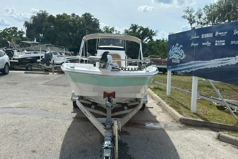 Slide: The Image of 2024 NauticStar 211 Hybrid boat on trailer at Holiday Marine dealership. - 4