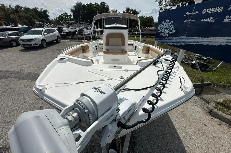 Slide: The Image of 2024 NauticStar 211 Hybrid boat displayed outdoors at a dealership. - 6