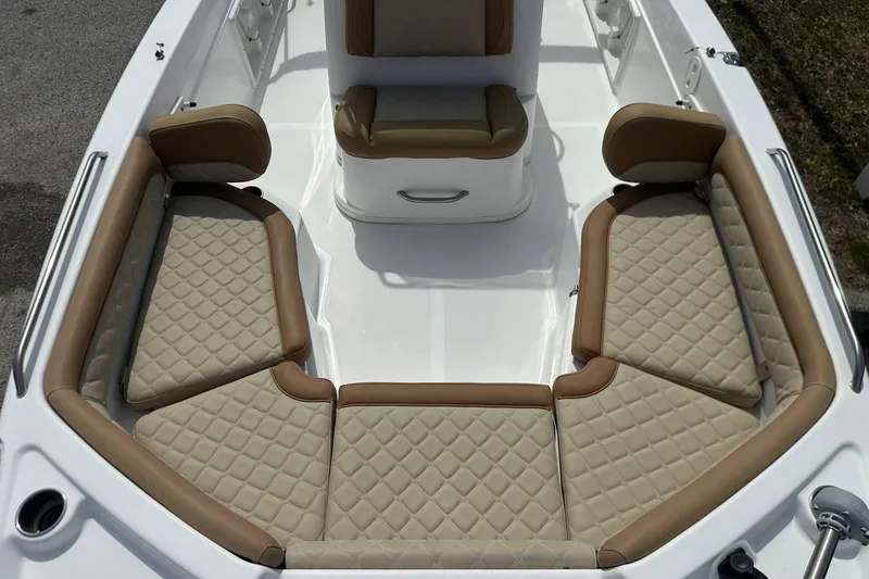Slide: The Image of 2024 NauticStar 211 Hybrid boat interior with tan quilted seating and white deck. - 9