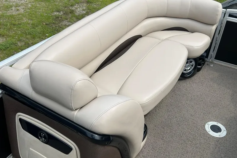 Slide: The Image of Luxurious beige seating on 2014 Regency 220 DL3 pontoon boat, featuring plush upholstery. - 11