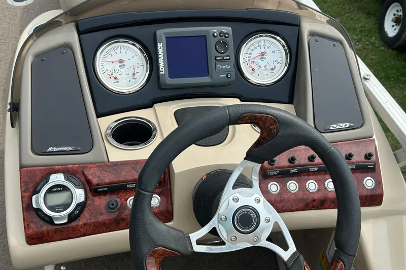 Slide: The Image of Dashboard of a 2014 Regency 220 DL3 boat with steering wheel and gauges. - 16